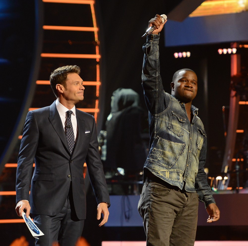 Ryan Seacrest in a professional setting, focusing on his work with a determined expression