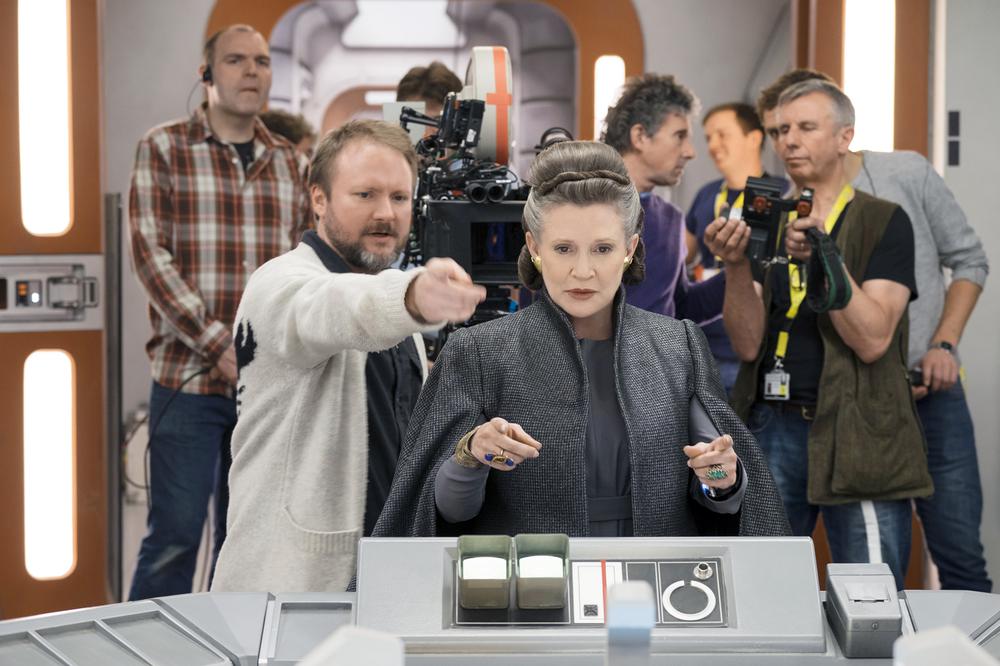 STAR WARS: THE LAST JEDI, FOREGROUND, FROM LEFT: DIRECTOR RIAN JOHNSON, CARRIE FISHER, ON SET, 2017. PH: DAVID JAMES/© WALT DISNEY STUDIOS MOTION PICTURES/LUCASFILM LTD.