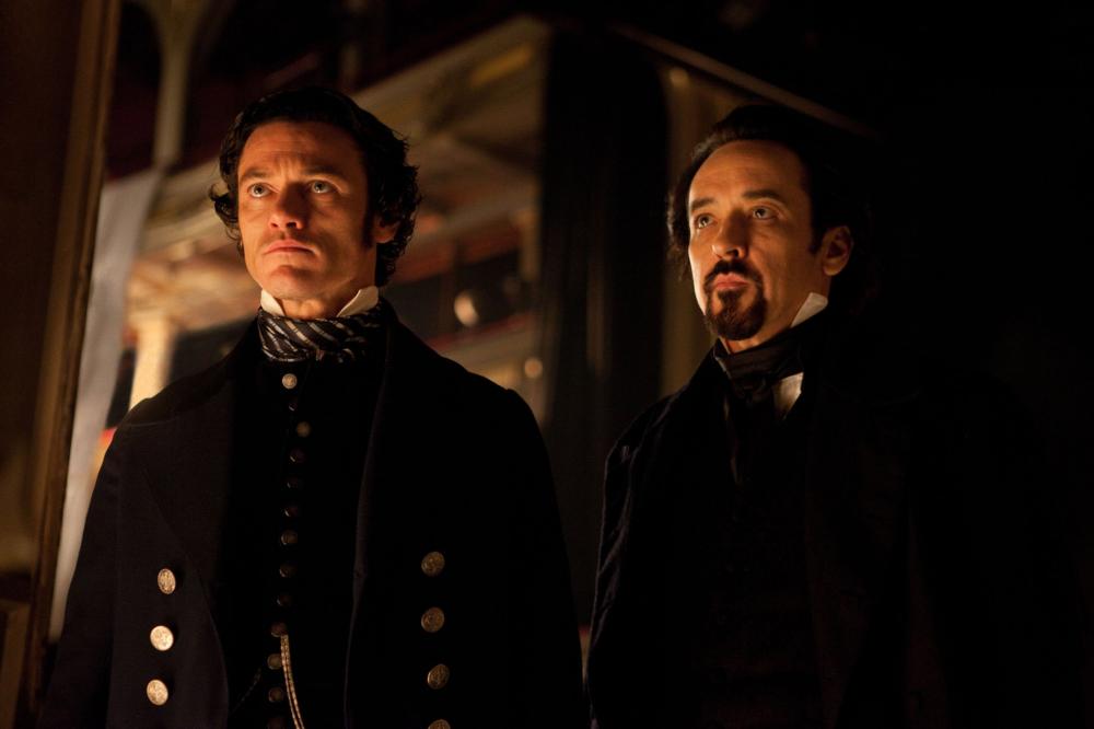 THE RAVEN, from left: Luke Evans, John Cusack, as Edgar Allan Poe, 2012. Ph: Larry Horricks/©Rogue Pictures