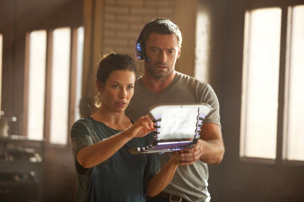 "REAL STEEL" RS-06357R Charlie Kenton (Hugh Jackman) and Bailey Tallet (Evangeline Lilly) study the command matrix on the controller's screen that sets the robot boxer Noisy Boy into action mode in DreamWorks Pictures' action drama "Real Steel". Ph: Mel