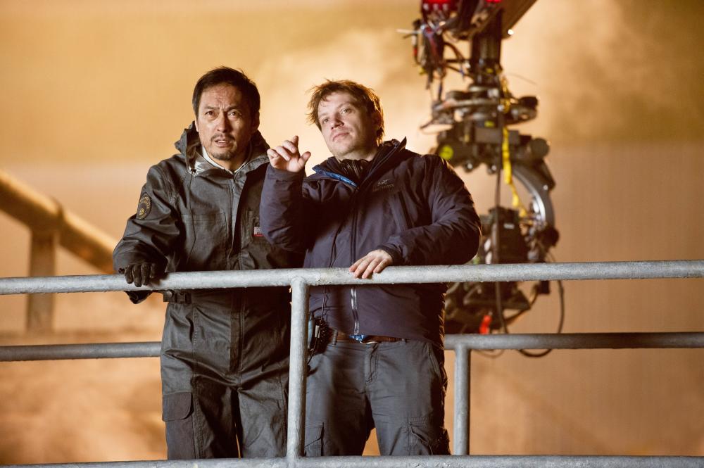 GODZILLA, from left: Ken Watanabe, director Gareth Edwards, on set, 2014. ph: Kimberley French/©Warner Bross. Pictures