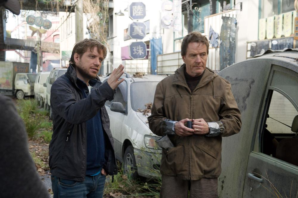 GODZILLA, from left: director Gareth Edwards, Bryan Cranston, on set, 2014. ph: Kimberley French/©Warner Bross. Pictures