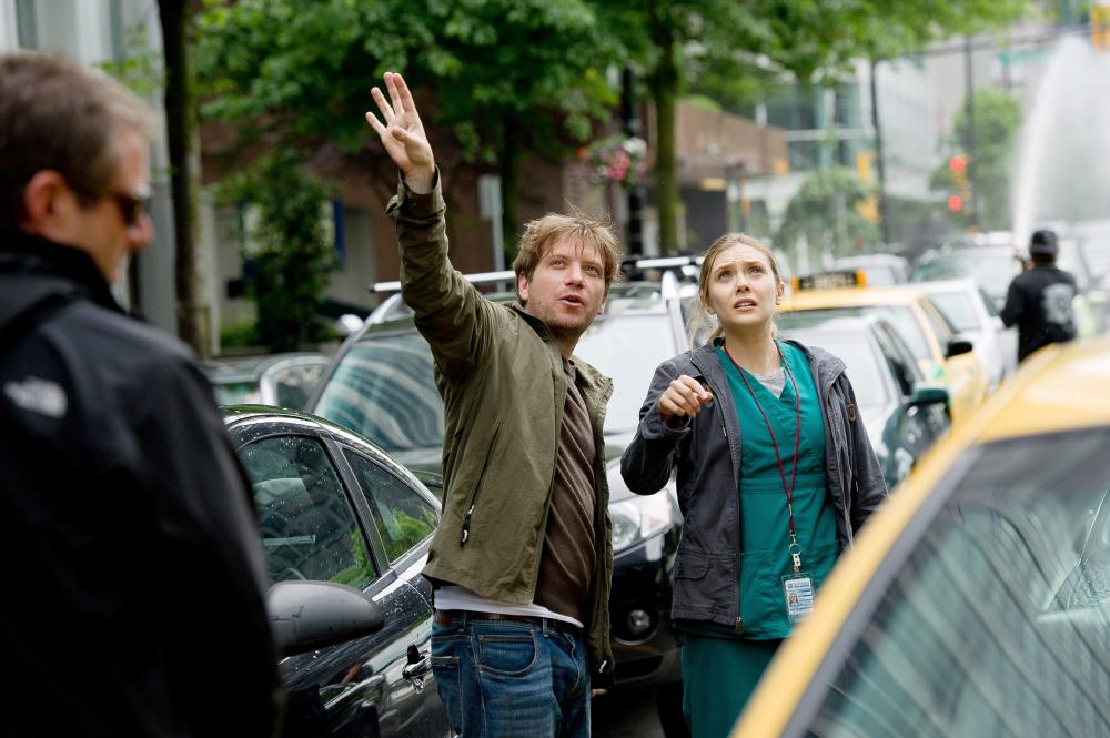 GODZILLA, from left: director Gareth Edwards, Elizabeth Olsen, on set, 2014. ph: Kimberley French/©Warner Bross. Pictures